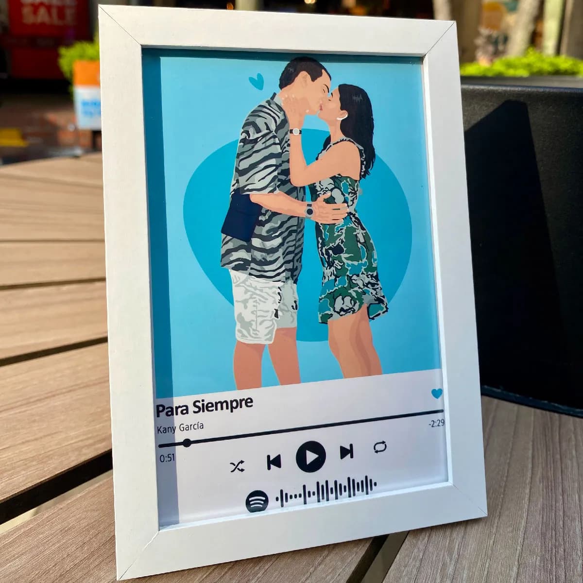 Portarretrato blanco con una pareja besándose y el código de Spotify de su canción